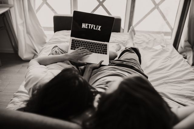 How to set up NordVPN for streaming abroad: keeping your home Netflix library available while travelling Two people watching Netflix on a laptop in bed while travelling abroad